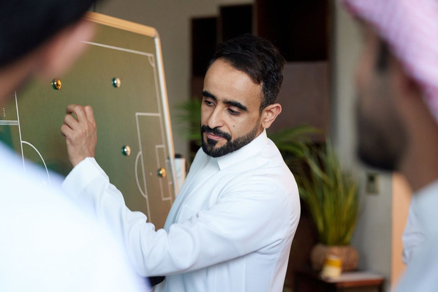 عبدالله الرشيد يوجّه فريق العمل أمام لوحة التخطيط في الموقع